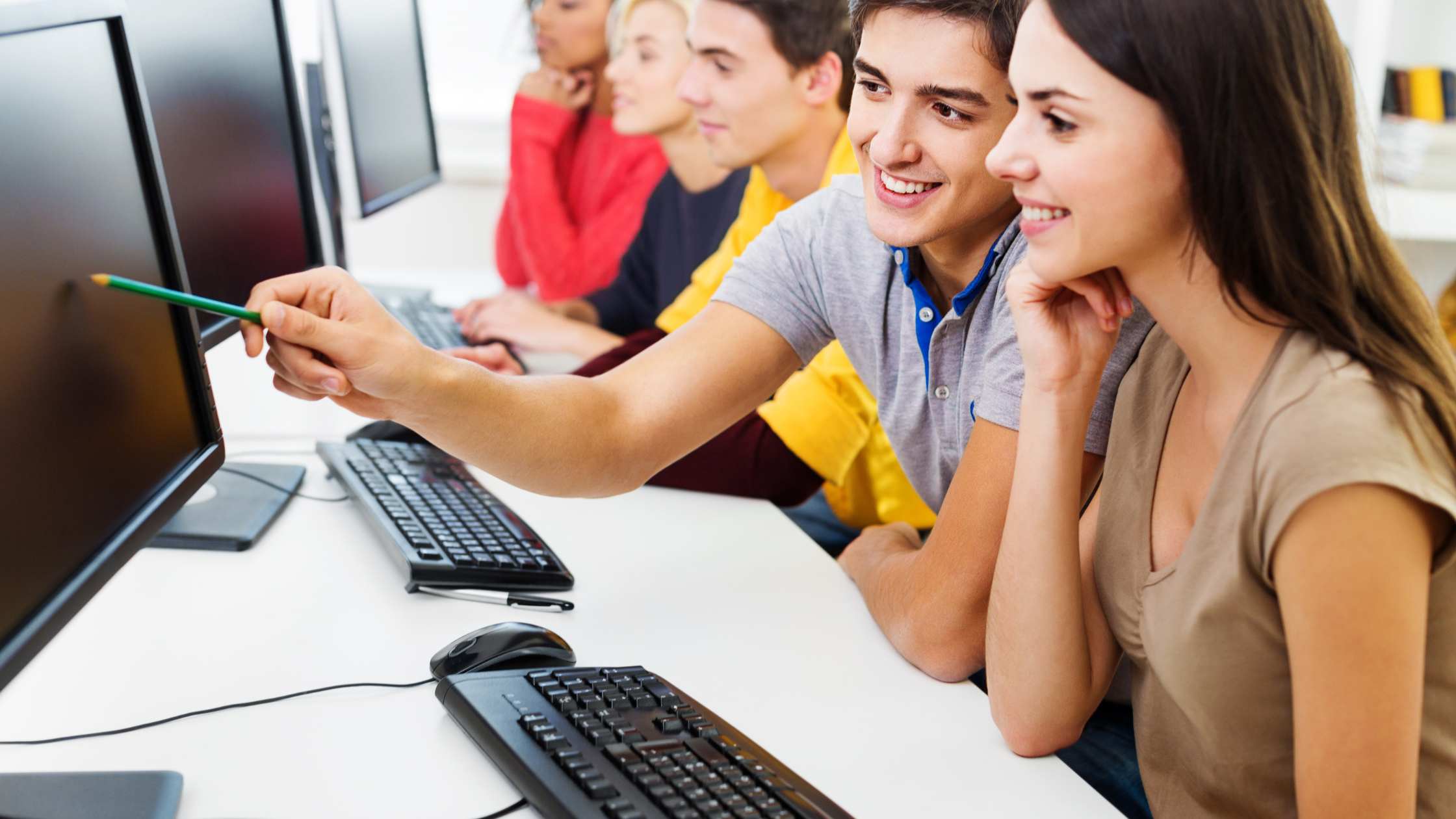 A group of interns working at computers, engaged in a professional environment, highlighting hands-on learning in the workplace."