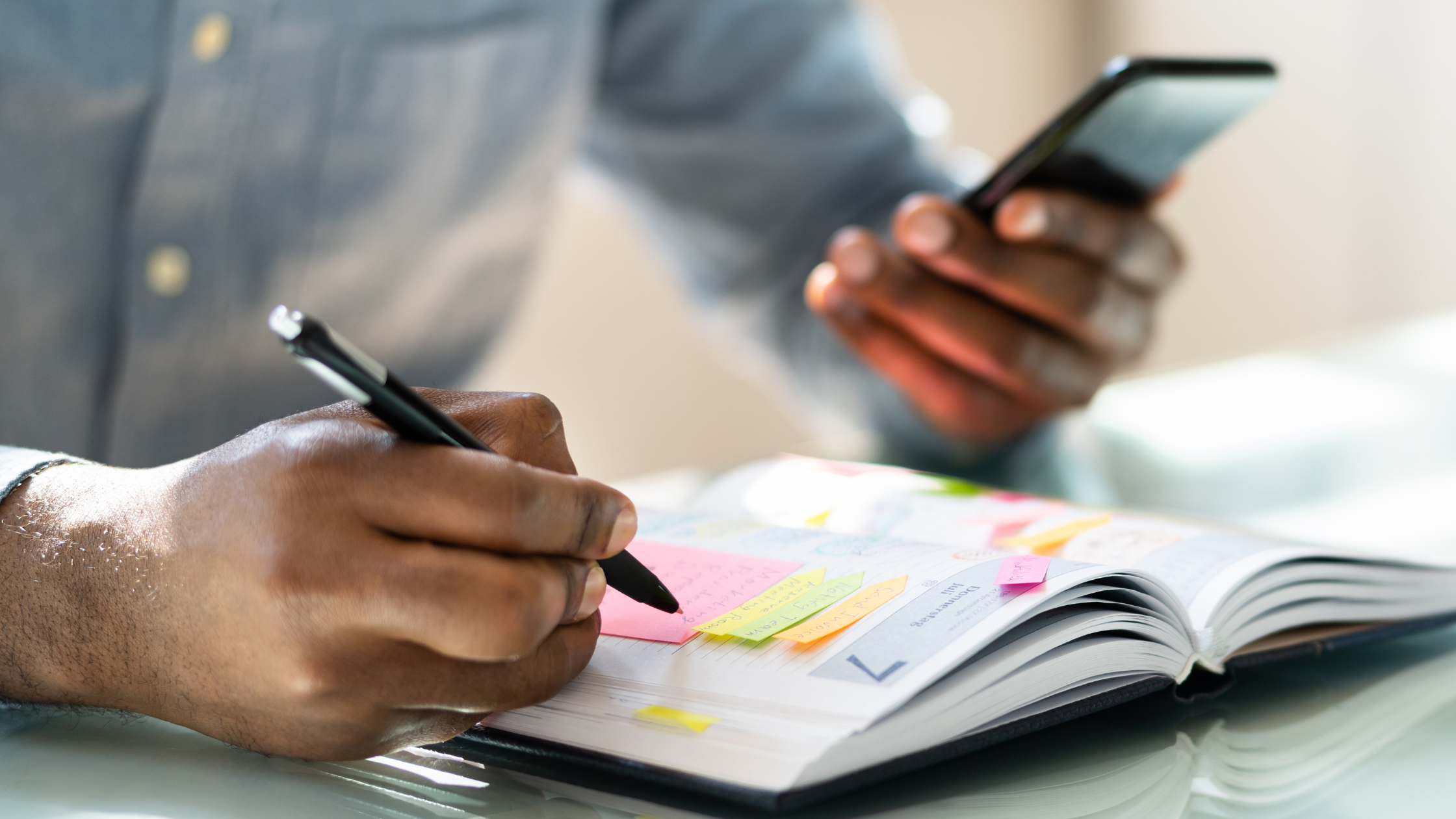 A man writing on a calendar or planner, organizing his schedule, illustrating the importance of time management for balancing responsibilities